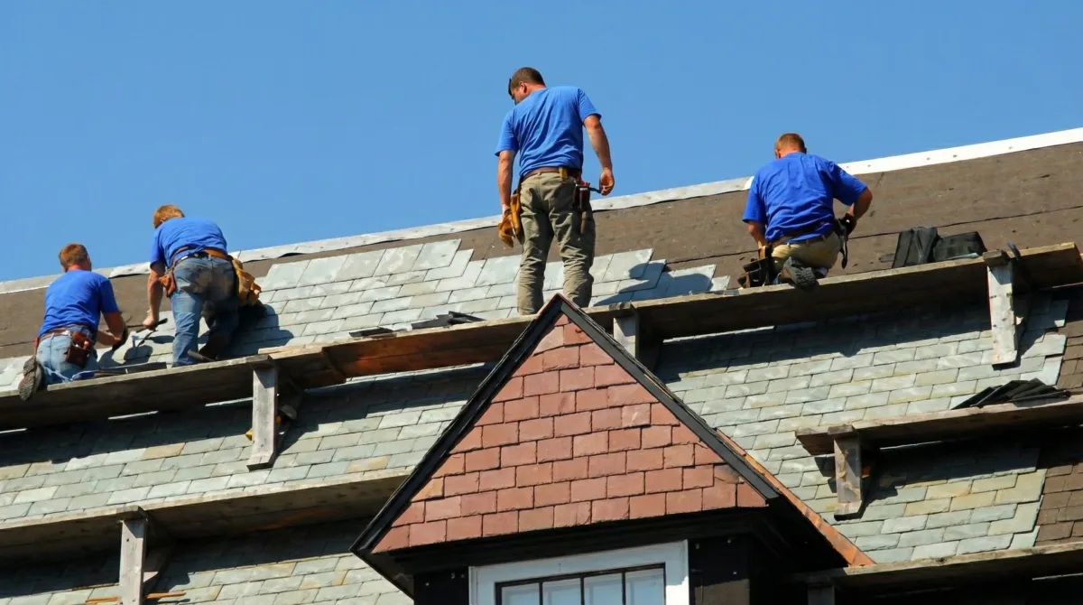 Roof replacement in progress with a team of professional contractors installing new shingles on a residential home in San Diego, CA
